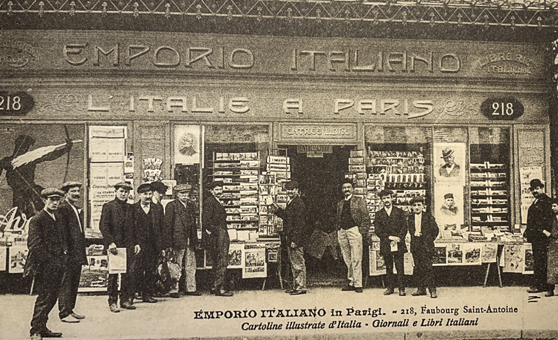 Magasin italien à Paris, vendeur de journaux Emporio Italiano, 1900 (carte postale, Musée national de l’histoire de l’immigration)